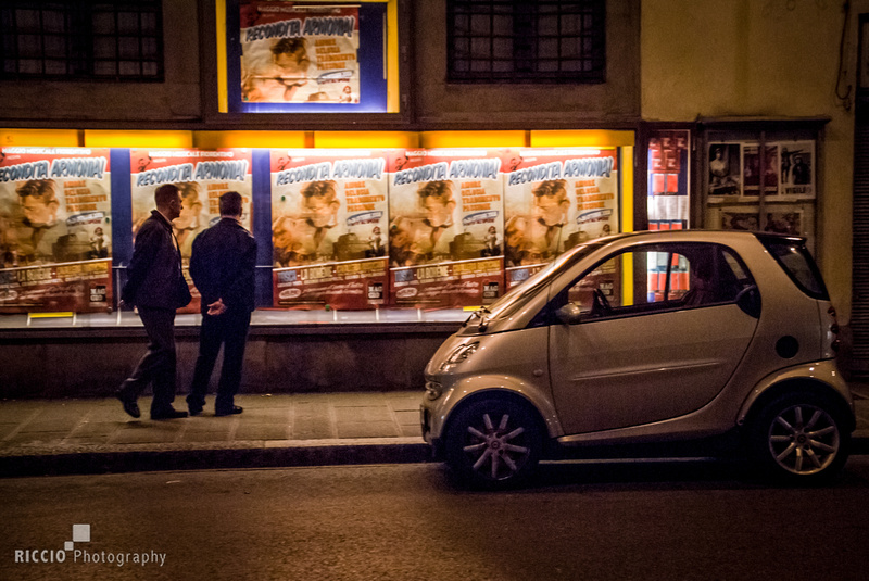 Movie posters at night. Street candid in Florence, Italy. Night photography